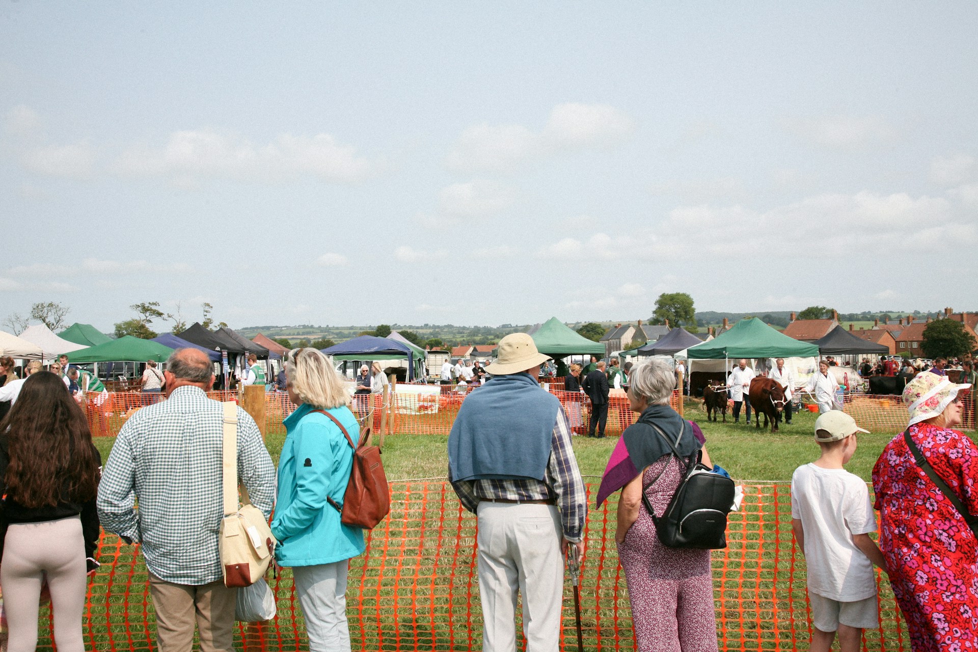 Yorkshire Shows for Summer Stone House Hotel Blog Image a small group f people stand in front of a fence in a field awaiting activity to start